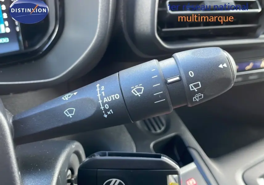 Gros plan sur la commande d’essuie-glace du Citroën Berlingo blanc glacier, intérieur noir avec tableau de bord visible.