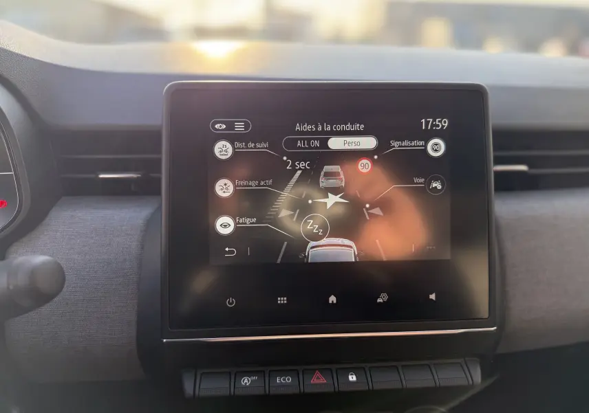 Écran tactile central de la Renault Clio V gris schiste, affichant les aides à la conduite en intérieur.