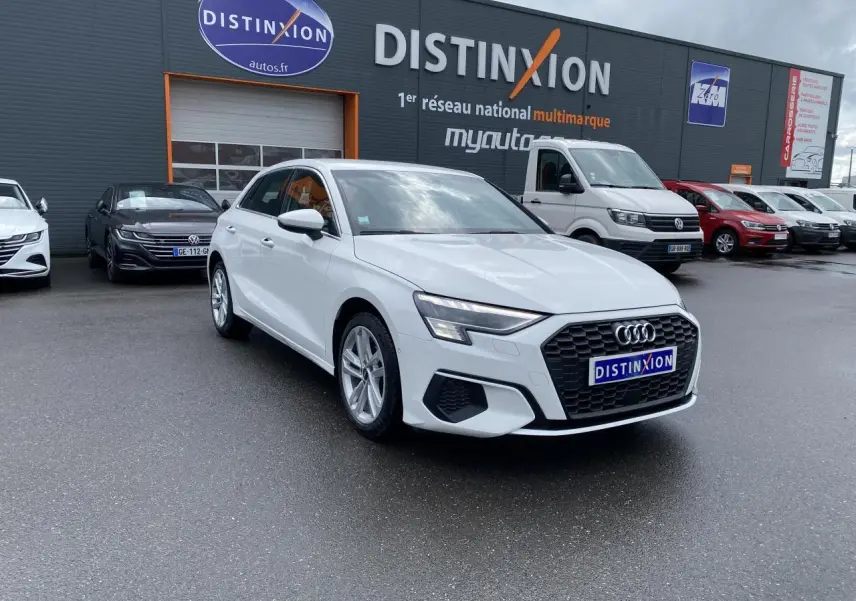 Audi A3 Sportback blanc Ibis vue 3/4 avant droit avec calandre noire et jantes alliage 18 pouces style étoile.