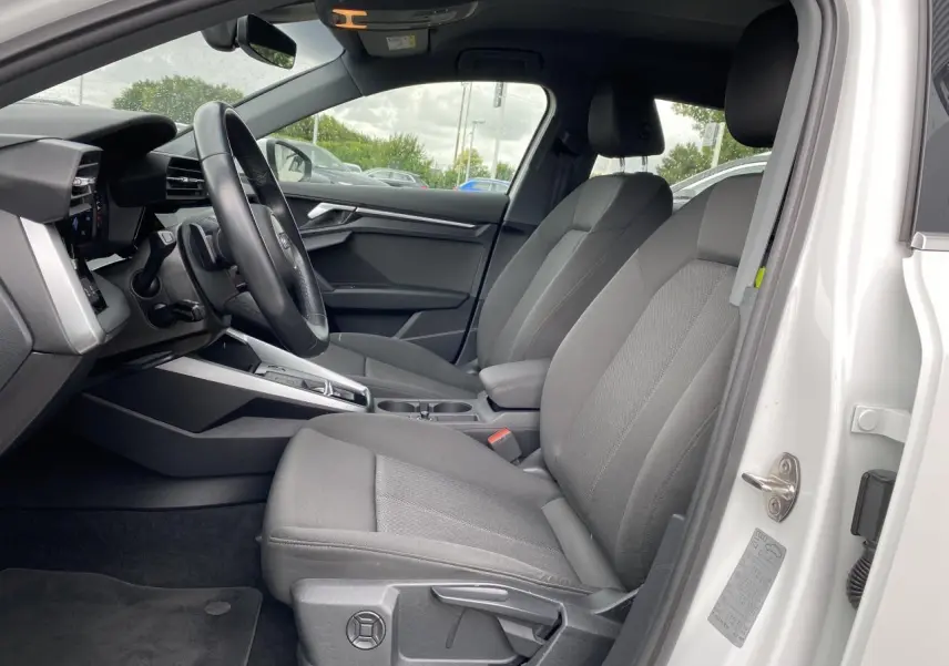 Intérieur côté conducteur Audi A3 Sportback blanc Ibis 2021, sièges tissu gris et volant cuir multifonctions.