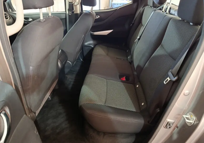 Vue intérieure arrière côté droit du Nissan Navara 2018 gris clair, montrant la banquette arrière en tissu noir et gris.