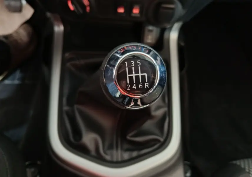 Gros plan sur le levier de vitesses manuel noir et chrome du Nissan Navara Double-Cab gris clair de 2018.