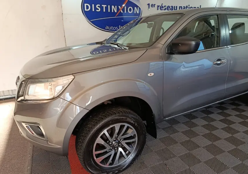 Vue 3/4 avant droit du Nissan Navara gris clair Double-Cab 2018 avec jantes alliage et rétroviseur noir.