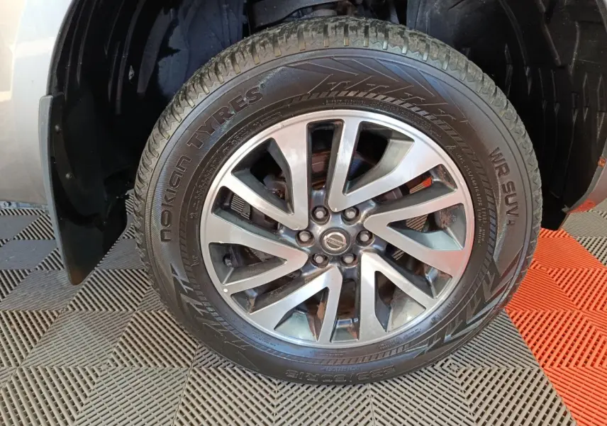 Gros plan sur la roue avant droite du Nissan Navara gris clair, jante alliage et pneu Nokian Tyres visible.