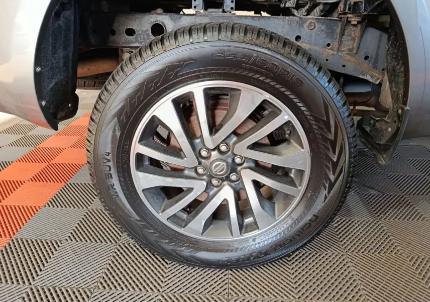 Gros plan sur la roue avant droite gris clair du Nissan Navara 2018, jante alliage et pneu tout-terrain visibles.