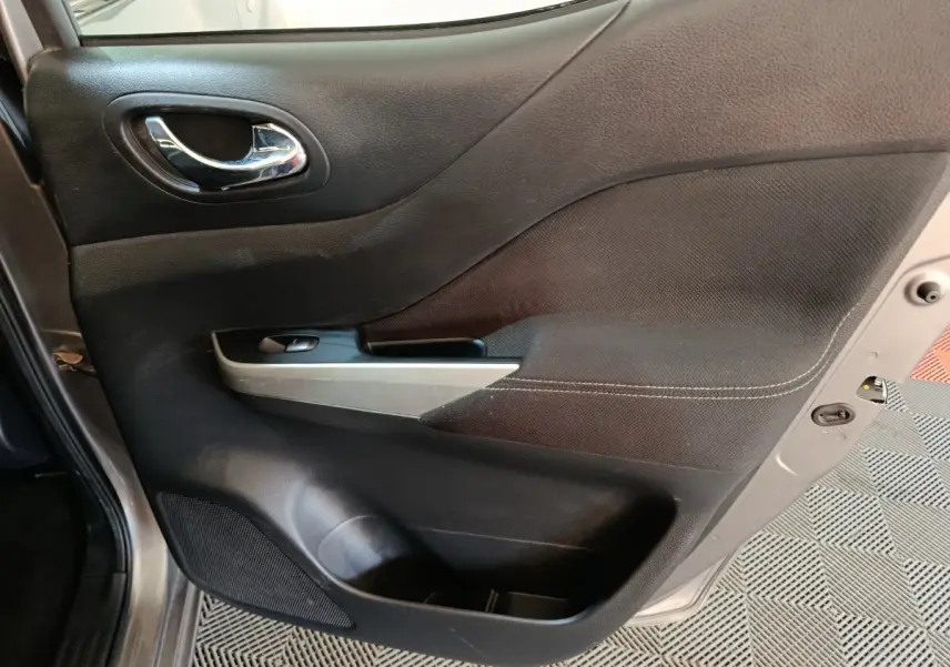 Vue rapprochée de la porte avant gauche gris clair du Nissan Navara 2018 avec poignée chrome et commande de fenêtre.