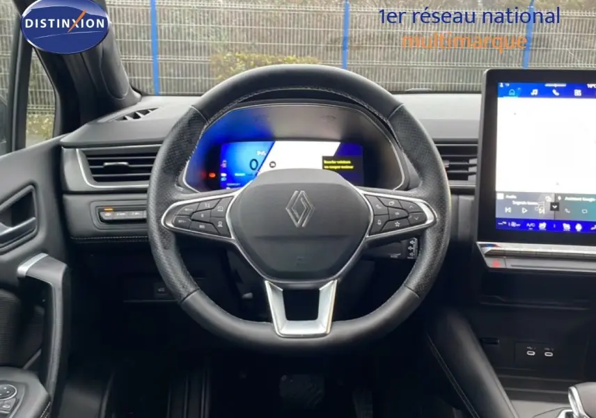 Vue intérieure centrée sur le volant noir du Renault Symbioz 2025 avec tableau de bord numérique et écran tactile.