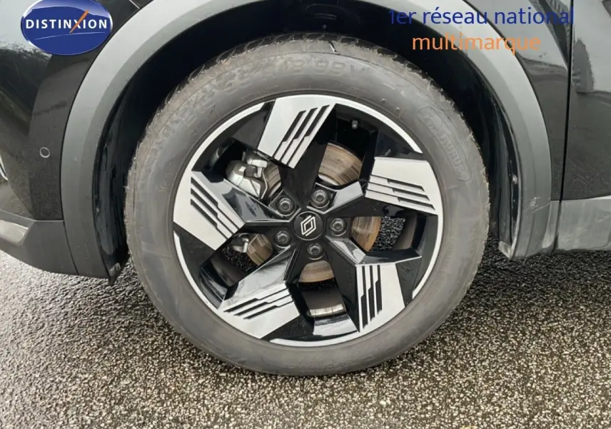 Gros plan sur la roue avant droite du Renault Symbioz noir étoile métal, mettant en valeur la jante au design moderne bicolore.