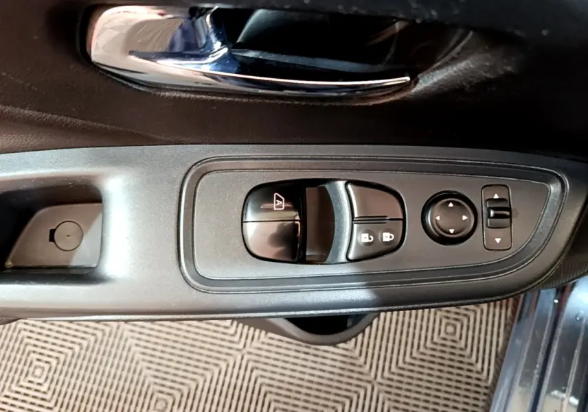 Vue rapprochée du panneau de commandes des vitres et rétroviseurs côté conducteur d’une Nissan Micra gris foncé 2020.