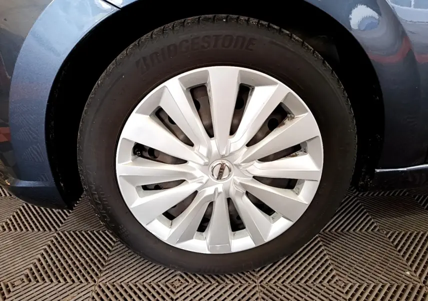 Gros plan sur la roue avant gauche d'une Nissan Micra gris foncé avec jante en alliage argenté et pneu Bridgestone.