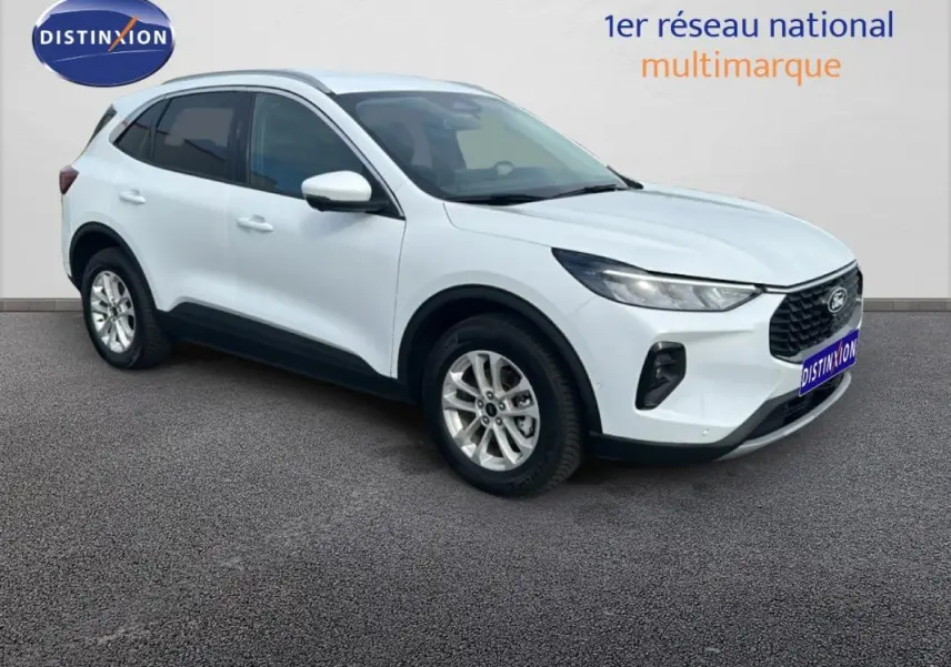 Ford Kuga blanc en 3/4 avant droit, avec barres de toit et jantes alliage 17 pouces visibles.