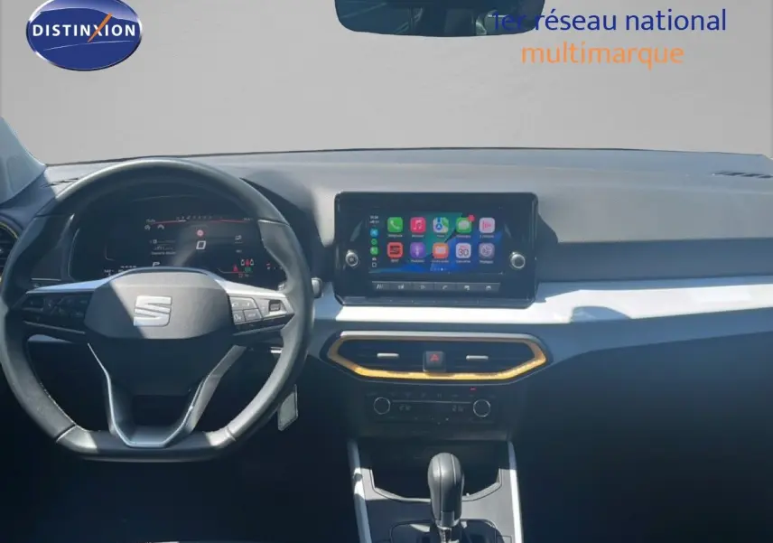 Vue intérieure frontale du tableau de bord du SEAT Arona 2025, avec écran tactile central et volant multifonction noir.
