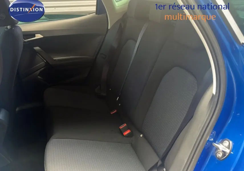 Vue intérieure côté droit montrant la banquette arrière noire du SEAT Arona bleu saphir 2025 avec porte ouverte.