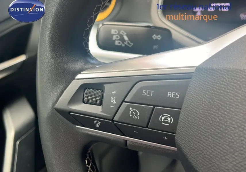 Gros plan sur les commandes au volant du SEAT Arona 2025, volant cuir noir avec boutons multifonctions.