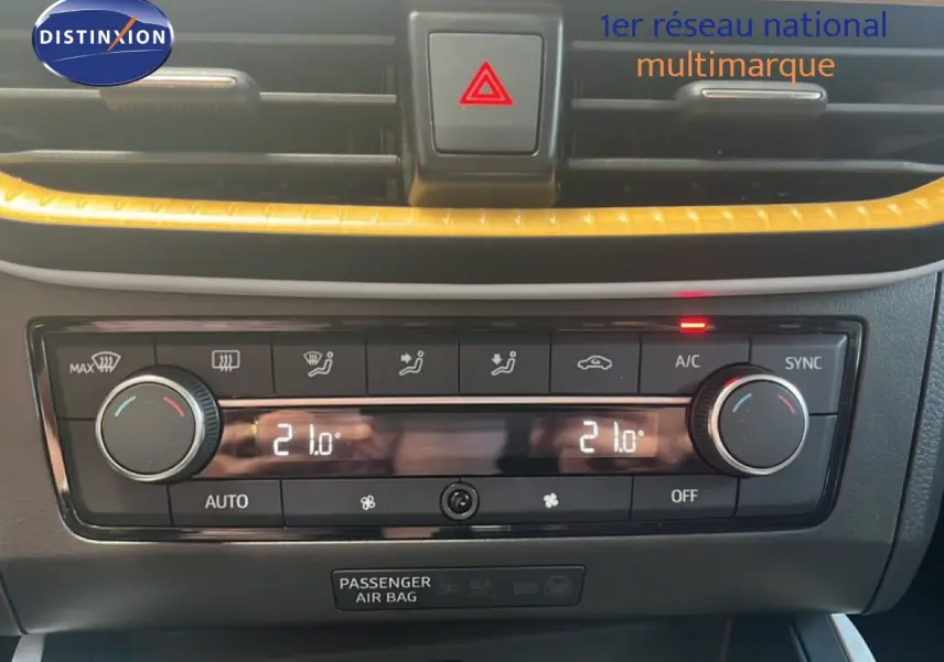 Gros plan sur la console centrale du SEAT Arona 2025, avec climatisation digitale et bandeau décoratif jaune.