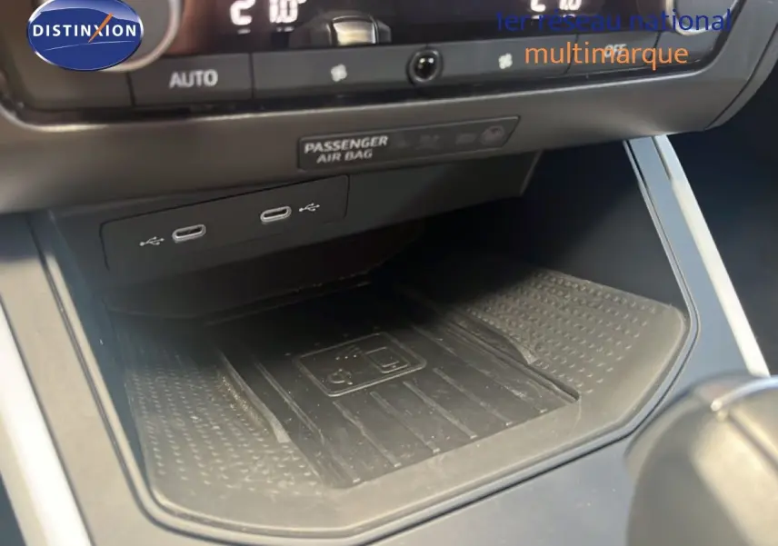 Gros plan sur la console centrale du SEAT Arona 2025, montrant les ports USB et le chargeur sans fil.