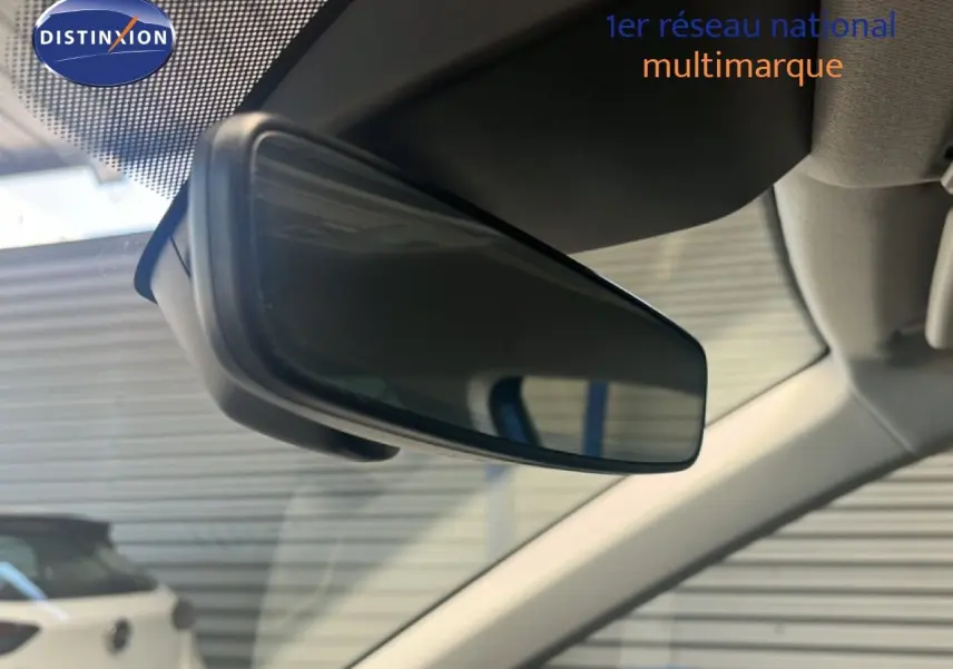 Rétroviseur intérieur en gros plan d'un SEAT Arona 2025 bleu saphir métal avec toit noir, vue depuis l'habitacle avant.