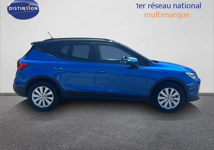 Vue de profil côté gauche d'un SEAT Arona 2025 bleu saphir avec toit noir, soulignant son design compact et moderne.