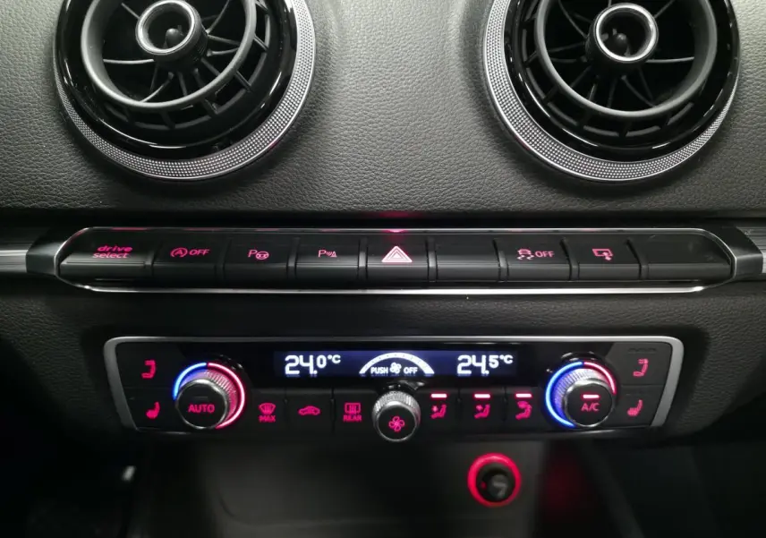 Détail du tableau de bord noir de l'Audi A3 Cabriolet 2015 avec commandes de climatisation automatique et aérateurs ronds chrome.