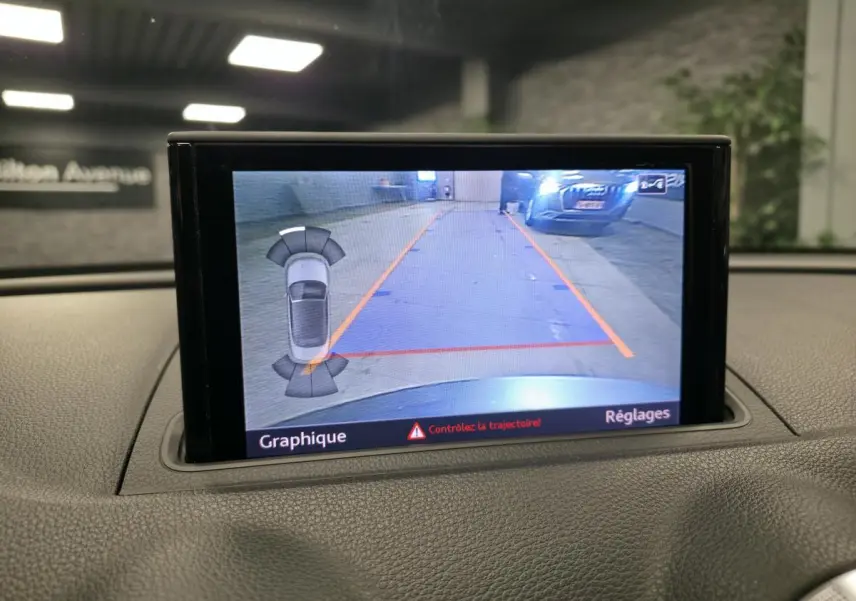 Écran MMI d'Audi A3 Cabriolet affichant la caméra de recul avec guidage de trajectoire en parking intérieur.
