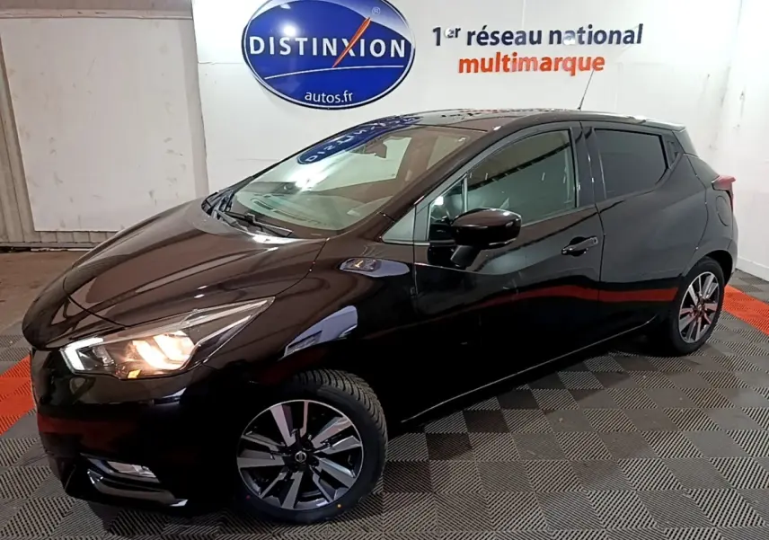 Nissan Micra IG-T 90 N-Connecta noire vue 3/4 avant droit, phares allumés, jantes alliage et rétroviseurs noirs.