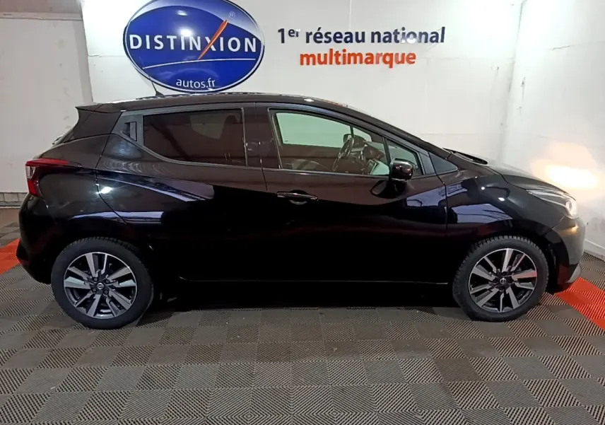 Profil côté gauche d'une Nissan Micra noire 2017, avec jantes alliage et vitres teintées, en intérieur showroom.