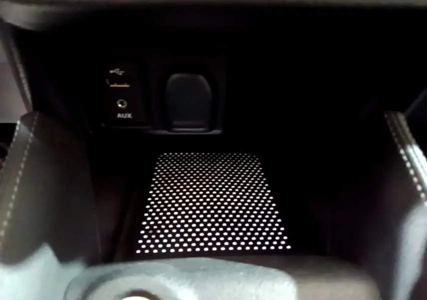 Gros plan sur la console centrale noire de la Nissan Micra IG-T 90 N-Connecta avec prise USB et port AUX visibles.