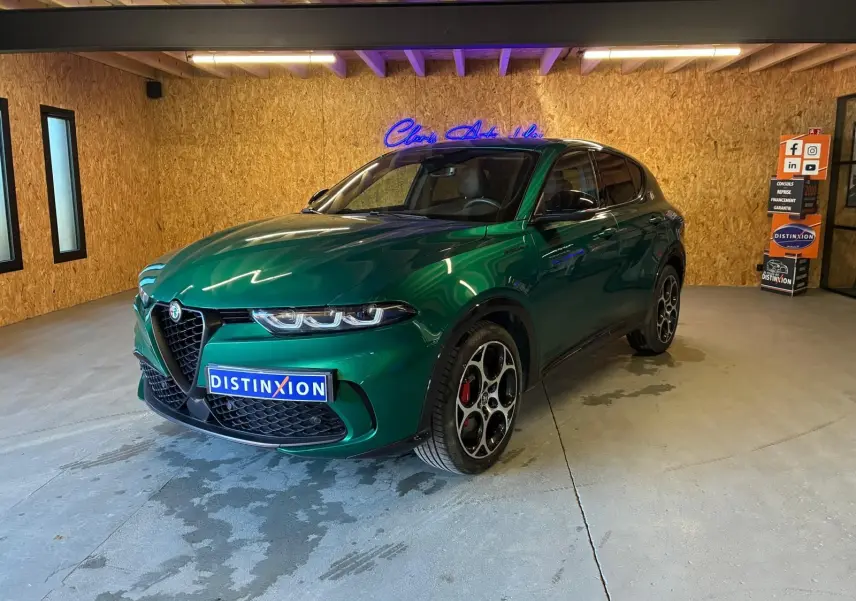 Vue 3/4 avant d'une Alfa Romeo Tonale 1.5 MHEV 130 TCT7 vert foncé avec jantes distinctives en intérieur showroom.