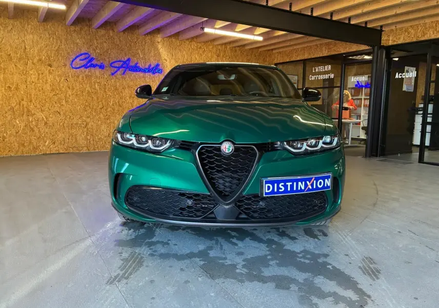 Vue frontale d'une Alfa Romeo Tonale 1.5 MHEV vert foncé, avec calandre emblématique en V et phares LED triples.