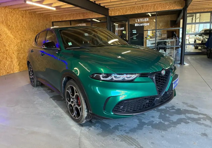 Alfa Romeo Tonale vert foncé en 3/4 avant droit, avec jantes distinctives et calandre triangulaire emblématique.