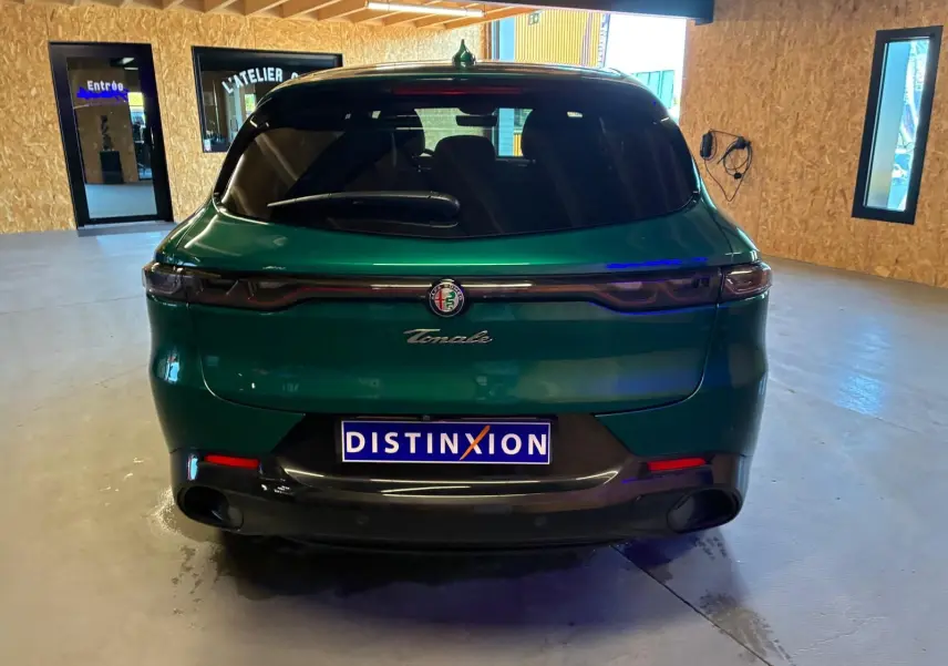 Vue arrière d'une Alfa Romeo Tonale vert foncé, avec feux arrière fins et logo centré sur le hayon.