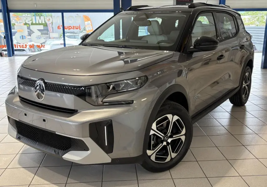Vue 3/4 avant d'un Citroën C3 Aircross 2026 gris métallisé avec toit noir et jantes alliage 17 pouces.
