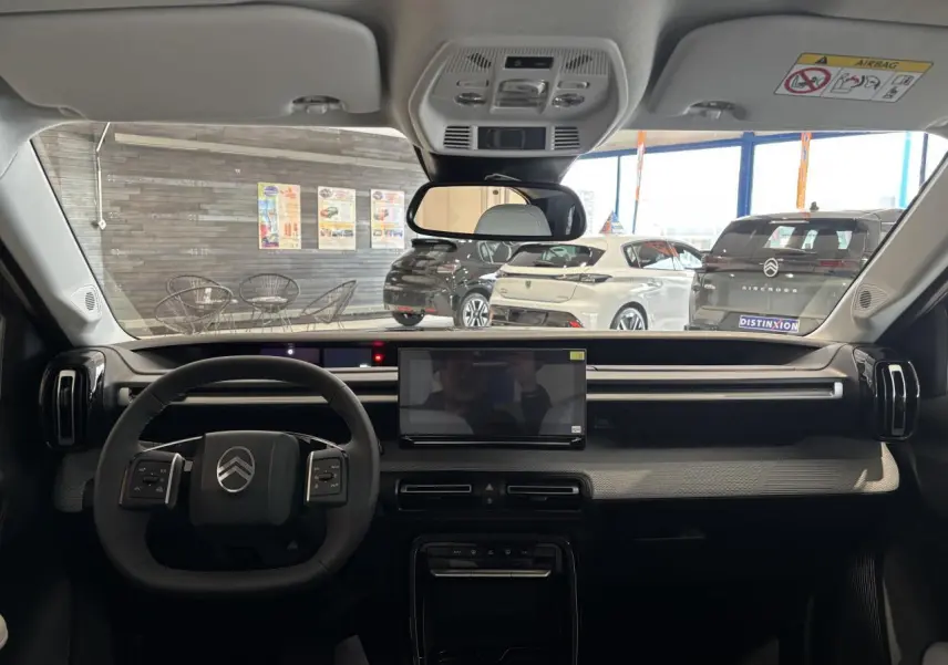Vue intérieure avant du Citroën C3 Aircross 2026 gris et noir, avec écran tactile central et volant multifonctions.