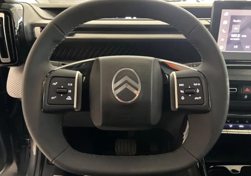 Vue rapprochée du volant multifonctions noir de la Citroën C3 Aircross 2026 avec logo chromé au centre.