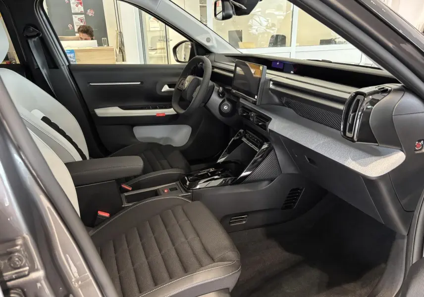 Vue intérieure côté conducteur du Citroën C3 Aircross 2026 gris et noir, avec tableau de bord moderne et écran tactile central.