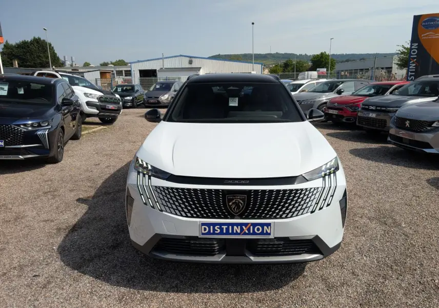 Vue avant d'un Peugeot 5008 blanc 2025 avec calandre noire à motifs et feux LED griffés, toit noir brillant.
