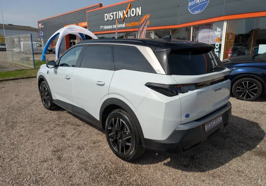 Peugeot 5008 blanc vue 3/4 arrière droit, toit noir, jantes alliage noires et feux arrière LED 3 griffes.