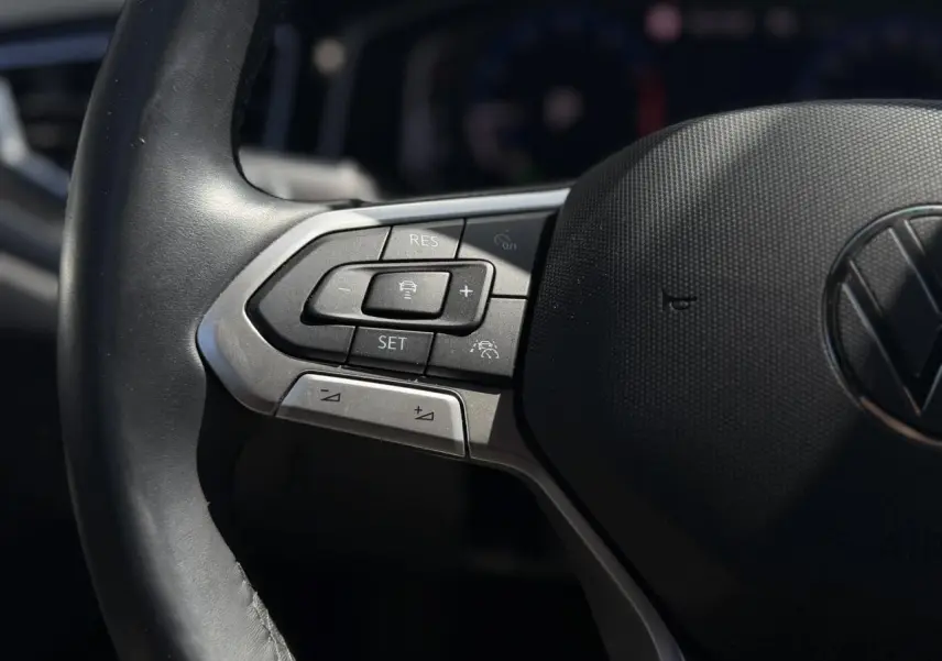 Gros plan sur les commandes du régulateur adaptatif au volant cuir du Volkswagen Taigo TSI 116 DSG R-Line 2025.