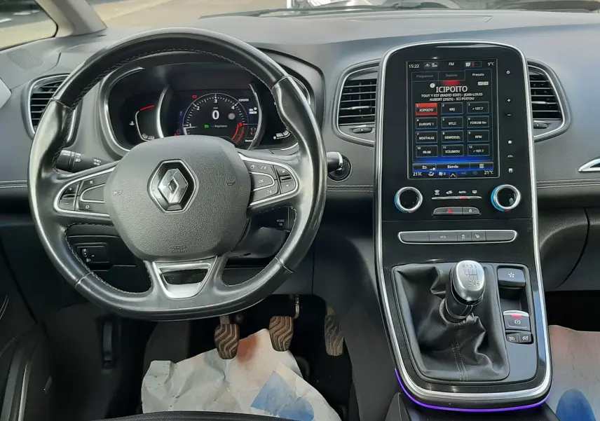 Vue intérieure côté gauche de la porte arrière d’un Renault Scenic IV gris Cassiopée avec pare-soleil en filet déployé.