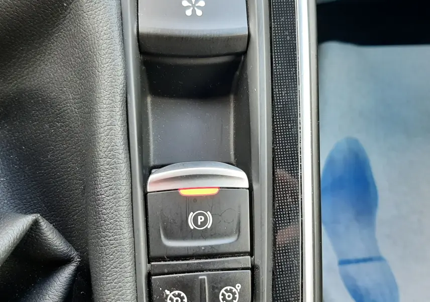 Vue plongeante sur le rangement central noir entouré de garnitures noires et d'un éclairage d'ambiance violet dans un Renault Scenic IV.