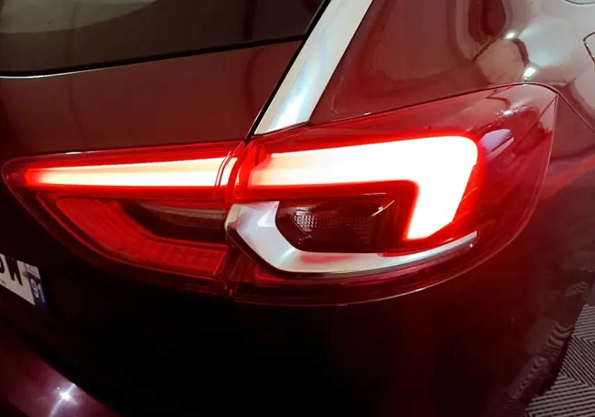 Gros plan sur le feu arrière droit rouge allumé d’une Opel Insignia rouge, finition Edition Business 2019.