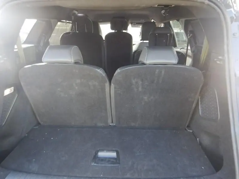 Vue depuis le coffre du Peugeot 5008 gris 2025, montrant les sièges arrière en tissu noir et l’espace intérieur.