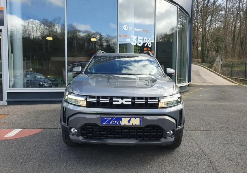 Vue avant d’un Dacia Dokker Van gris schiste avec calandre noire et feux LED, stationné devant une vitrine.