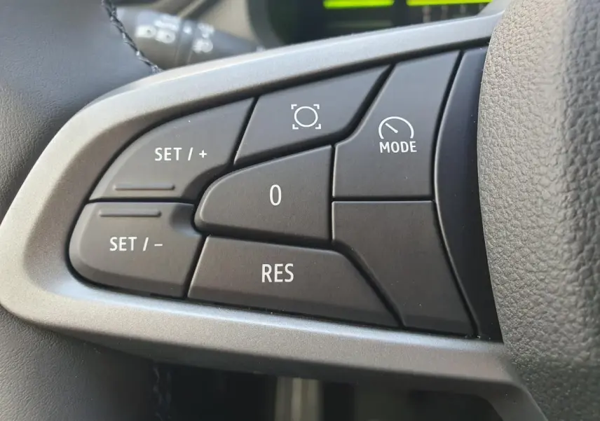 Gros plan sur les commandes de régulateur de vitesse au volant du Dacia Dokker Van gris schiste, version 2026.