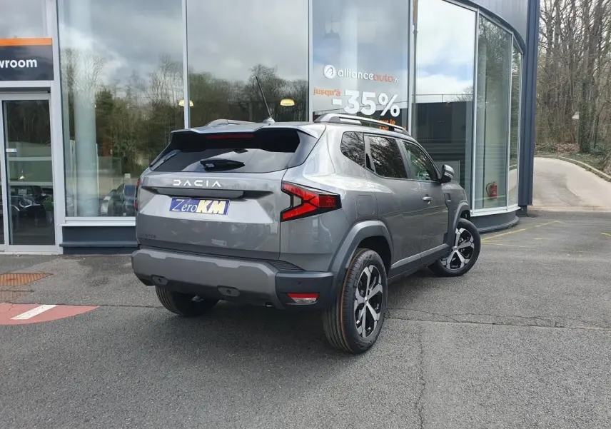 Vue 3/4 arrière droit d'un Dacia Dokker Van gris schiste métallisé avec jantes alliage et barres de toit fixes.