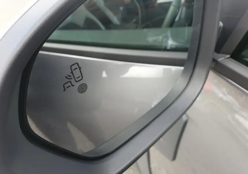 Rétroviseur côté droit du Dacia Dokker Van gris schiste 2026 avec icône d’alerte de changement de file visible.