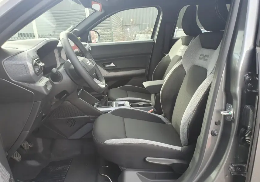 Vue intérieure côté conducteur du Dacia Dokker Van gris schiste, montrant les sièges avant et le tableau de bord.