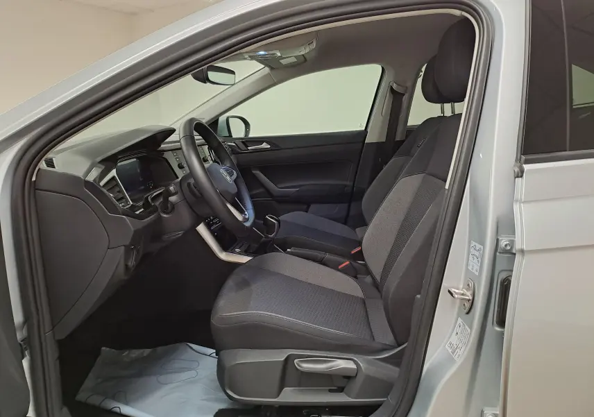 Intérieur côté conducteur du Volkswagen Taigo 2025 argent, montrant sièges tissu gris et tableau de bord moderne.