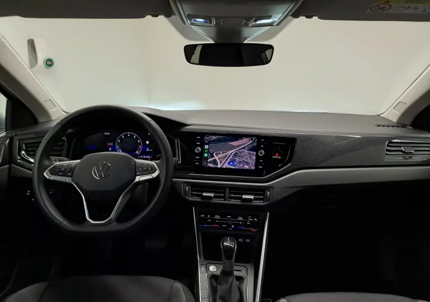 Vue intérieure du tableau de bord du Volkswagen Taigo 2025, avec volant multifonction et écran tactile central allumé.