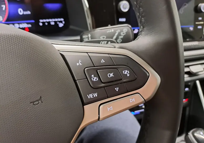 Gros plan sur les commandes au volant du Volkswagen Taigo 1.0 TSI 116 DSG7, finition VW Edition, intérieur noir.